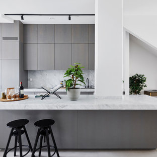 Exempel på ett minimalistiskt grå linjärt grått kök med öppen planlösning, med en undermonterad diskho, släta luckor, grå skåp, grått stänkskydd, en köksö och beiget golv