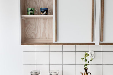 Exempel på ett 50 tals kök och matrum, med en dubbel diskho, vita skåp, bänkskiva i rostfritt stål, vitt stänkskydd och vita vitvaror