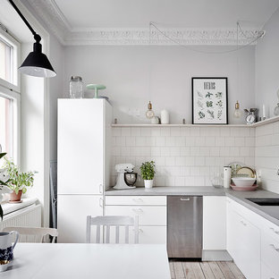 Inspiration för mellanstora skandinaviska grått kök, med vita skåp, bänkskiva i betong, vitt stänkskydd, beiget golv, en undermonterad diskho, släta luckor och ljust trägolv