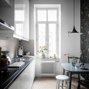 Idéer för att renovera ett litet skandinaviskt svart svart kök och matrum, med släta luckor, en nedsänkt diskho, vita skåp, grått stänkskydd, stänkskydd i mosaik, ljust trägolv och beiget golv