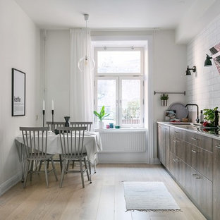 Idéer för ett mellanstort skandinaviskt beige linjärt kök och matrum, med släta luckor, skåp i mörkt trä, vitt stänkskydd, integrerade vitvaror, ljust trägolv, beiget golv, stänkskydd i tunnelbanekakel och en enkel diskho