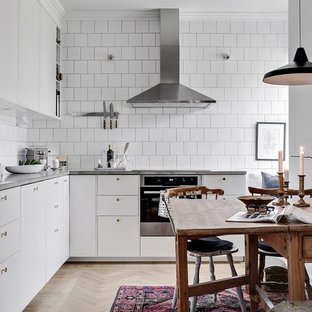Idéer för att renovera ett skandinaviskt kök, med släta luckor, vita skåp, ljust trägolv, beiget golv och vitt stänkskydd