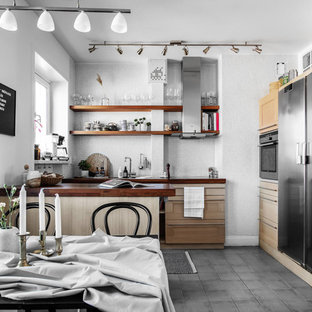 Bild på ett mellanstort minimalistiskt brun brunt kök, med skåp i ljust trä, grått stänkskydd, stänkskydd i mosaik, en halv köksö, grått golv, skåp i shakerstil, träbänkskiva och rostfria vitvaror