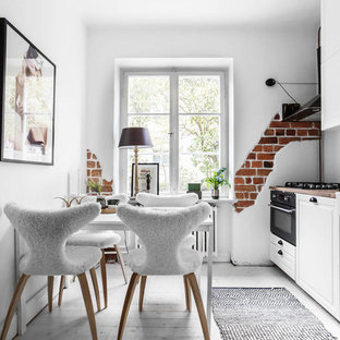 Exempel på ett mellanstort minimalistiskt linjärt kök och matrum, med vitt golv, en rustik diskho, luckor med upphöjd panel, vita skåp, svarta vitvaror och målat trägolv