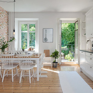 Immagine di una cucina scandinava di medie dimensioni con lavello a doppia vasca, ante di vetro, ante bianche, paraspruzzi bianco, pavimento in legno massello medio, nessuna isola e top in acciaio inossidabile