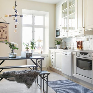 Idéer för ett minimalistiskt linjärt kök och matrum, med luckor med glaspanel, vitt stänkskydd, stänkskydd i porslinskakel, vita vitvaror, beige skåp, ljust trägolv och beiget golv