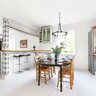 Minimalistisk inredning av ett mellanstort linjärt kök med öppen planlösning, med gröna skåp, träbänkskiva, vitt stänkskydd, rostfria vitvaror, en halv köksö, vitt golv och målat trägolv