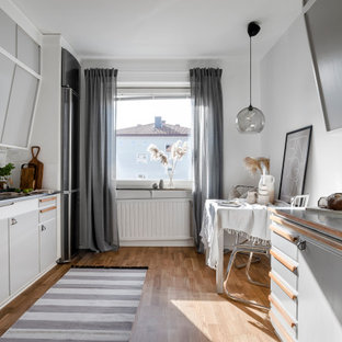 Inspiration för små skandinaviska grått kök, med en dubbel diskho, släta luckor, grå skåp, rostfria vitvaror och brunt golv