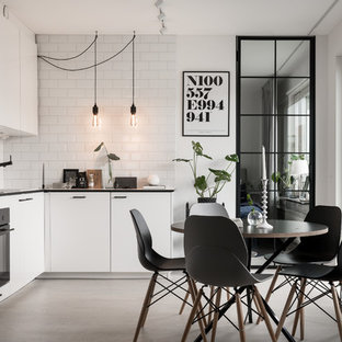 Foto på ett mellanstort nordiskt l-kök, med släta luckor, vita skåp, integrerade vitvaror, betonggolv och vitt golv
