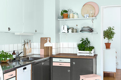 Imagen de cocinas en L nórdica pequeña con fregadero de doble seno, puertas de armario grises, salpicadero blanco, electrodomésticos blancos y suelo de madera clara