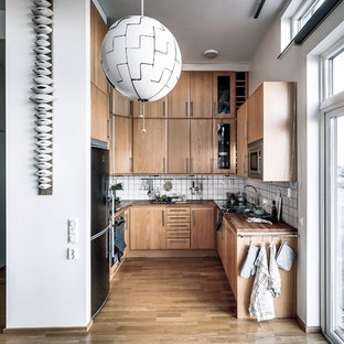 Inspiration för ett minimalistiskt brun brunt u-kök, med en nedsänkt diskho, släta luckor, skåp i mellenmörkt trä, träbänkskiva, vitt stänkskydd, rostfria vitvaror, mellanmörkt trägolv och brunt golv