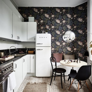 Photo of a mid-sized scandinavian l-shaped eat-in kitchen in Gothenburg with flat-panel cabinets, white cabinets, white appliances, light hardwood floors, no island and a double-bowl sink.