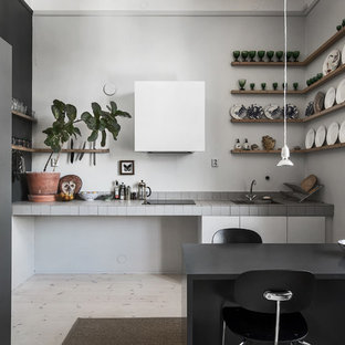 Mid-sized scandinavian single-wall eat-in kitchen in Stockholm with open cabinets, tile benchtops, white splashback, light hardwood floors and no island.