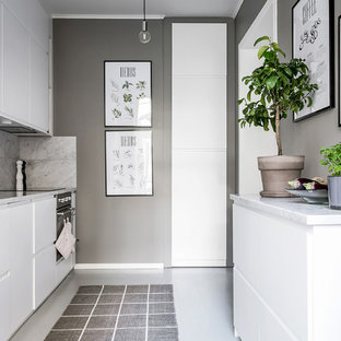 Inspiration för ett avskilt nordiskt parallellkök, med en undermonterad diskho, släta luckor, vita skåp, marmorbänkskiva, grått stänkskydd, stänkskydd i marmor, svarta vitvaror och vitt golv