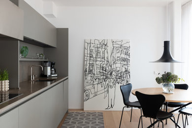 Medium sized classic single-wall open plan kitchen in Stockholm with flat-panel cabinets and grey cabinets.