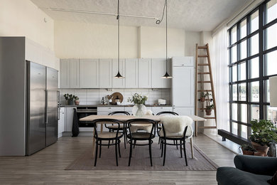 Idéer för att renovera ett nordiskt grå grått kök, med skåp i shakerstil, blå skåp, vitt stänkskydd, stänkskydd i tunnelbanekakel, rostfria vitvaror, mellanmörkt trägolv och brunt golv