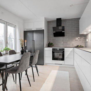 Bild på ett mellanstort minimalistiskt grå grått kök, med en enkel diskho, släta luckor, vita skåp, laminatbänkskiva, grått stänkskydd, stänkskydd i porslinskakel, rostfria vitvaror och beiget golv
