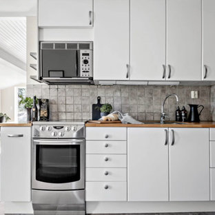 Inspiration för ett litet minimalistiskt beige linjärt beige kök och matrum, med en dubbel diskho, släta luckor, vita skåp, träbänkskiva, flerfärgad stänkskydd, stänkskydd i stenkakel, rostfria vitvaror, skiffergolv och flerfärgat golv