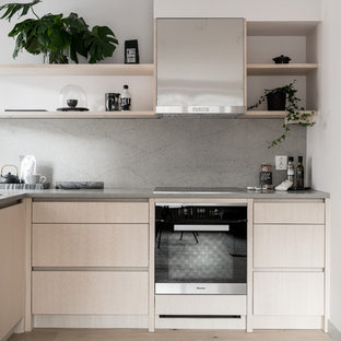 Inspiration för ett litet nordiskt kök, med släta luckor, skåp i ljust trä, bänkskiva i betong, ljust trägolv, en halv köksö, beiget golv, en undermonterad diskho, grått stänkskydd och svarta vitvaror