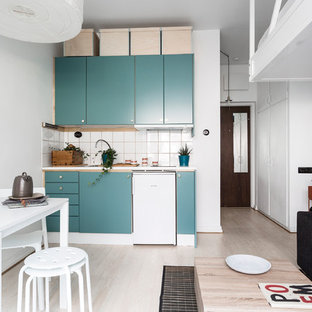Esempio di una piccola cucina scandinava con ante lisce, ante turchesi, paraspruzzi bianco, elettrodomestici bianchi, parquet chiaro, nessuna isola e pavimento beige