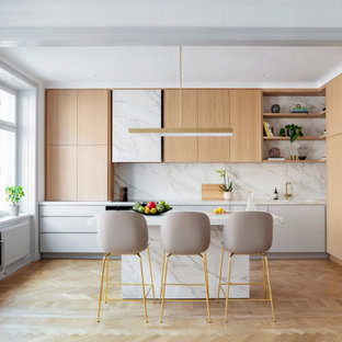 Idéer för ett stort modernt grå kök, med en undermonterad diskho, släta luckor, beige skåp, grått stänkskydd, stänkskydd i porslinskakel, integrerade vitvaror, mellanmörkt trägolv, en köksö och beiget golv