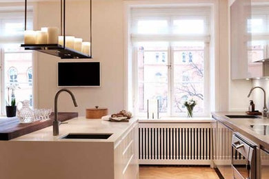 Exempel på ett mellanstort modernt kök och matrum, med en enkel diskho, släta luckor, grå skåp, bänkskiva i betong, vitt stänkskydd, glaspanel som stänkskydd, rostfria vitvaror, mörkt trägolv, en köksö och brunt golv
