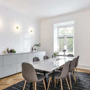 Inspiration för stora nordiska linjära kök och matrum, med grå skåp, marmorbänkskiva, vitt stänkskydd, en undermonterad diskho, släta luckor, stänkskydd i tunnelbanekakel och ljust trägolv