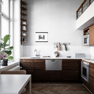 Exempel på ett litet minimalistiskt vit vitt kök, med en nedsänkt diskho, släta luckor, skåp i mellenmörkt trä, vitt stänkskydd, mörkt trägolv och brunt golv