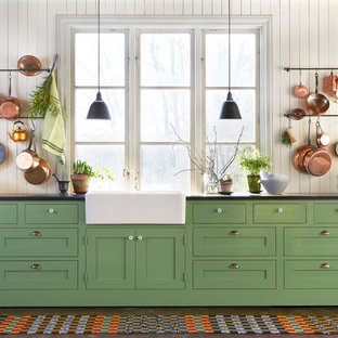 Inspiration for an expansive country single-wall kitchen in Stockholm with a farmhouse sink, shaker cabinets, green cabinets, dark hardwood floors, laminate benchtops and no island.