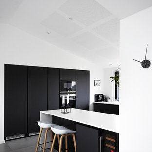 Foto di una cucina moderna di medie dimensioni con ante lisce, ante nere, top in laminato, pavimento con piastrelle in ceramica e penisola