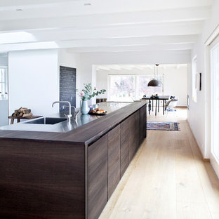 Esempio di una grande cucina abitabile minimalista con lavello integrato, ante lisce, ante in legno bruno, top in legno, parquet chiaro e isola