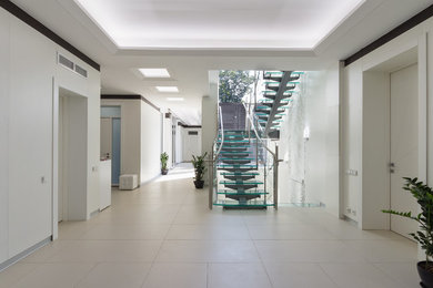 На фото: большой коридор: освещение в стиле лофт с белыми стенами, полом из керамогранита и бежевым полом