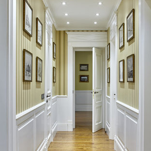 Exemple d'un couloir chic avec un mur beige et un sol en bois brun.