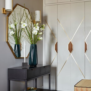 Idée de décoration pour un couloir design avec un mur beige et un sol noir.