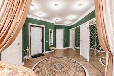 На фото: коридор с зелеными стенами и полом из ламината с
