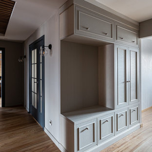 Idées déco pour un couloir contemporain de taille moyenne avec un mur blanc, sol en stratifié, un sol marron, un plafond en bois et du lambris.