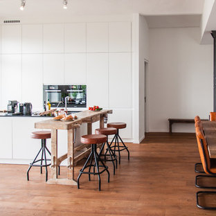 Foto di un'ampia cucina ad ambiente unico stile shabby con ante bianche, top in granito e pavimento in legno massello medio