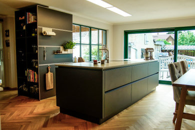 Geschlossene, Mittelgroße Moderne Küche mit schwarzen Schränken und Kücheninsel in Leipzig