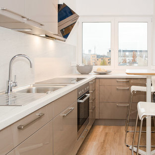 Geschlossene, Kleine Moderne Küche ohne Insel in L-Form mit Einbauwaschbecken, flächenbündigen Schrankfronten, braunen Schränken, Marmor-Arbeitsplatte, Küchenrückwand in Weiß, Rückwand aus Marmor, schwarzen Elektrogeräten, braunem Holzboden und braunem Boden in Berlin