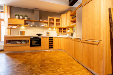 Moderne Küche in L-Form mit hellen Holzschränken in Hannover