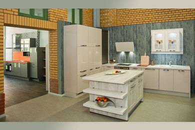 Mittelgroße Moderne Wohnküche in L-Form mit flächenbündigen Schrankfronten, Küchengeräten aus Edelstahl, Kücheninsel und Laminat-Arbeitsplatte in Sonstige