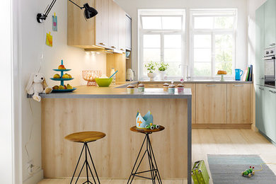 Offene, Mittelgroße Moderne Küche ohne Insel in U-Form mit flächenbündigen Schrankfronten, hellen Holzschränken, Küchenrückwand in Weiß und hellem Holzboden in Sonstige
