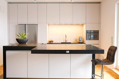 Mittelgroße, Geschlossene Moderne Küche mit braunem Holzboden und braunem Boden in Berlin