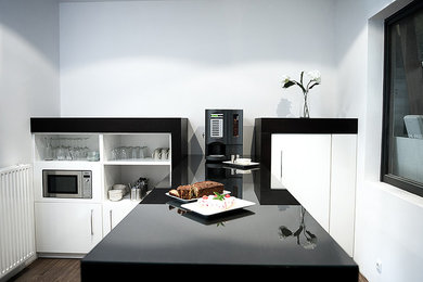 Offene, Einzeilige, Kleine Moderne Küche mit weißen Schränken, Küchengeräten aus Edelstahl und Kücheninsel in Hamburg
