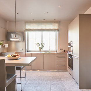 Große Moderne Wohnküche in L-Form mit flächenbündigen Schrankfronten, grauen Schränken, Küchenrückwand in Beige, Küchengeräten aus Edelstahl, Terrazzo-Boden, Halbinsel, beigem Boden, beiger Arbeitsplatte und Unterbauwaschbecken in Hamburg