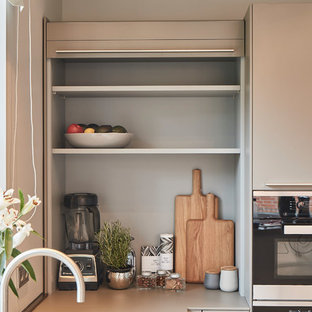 Foto de cocina en L, contemporánea, grande, abierta, con fregadero integrado, armarios con paneles lisos, puertas de armario grises, encimera de madera, salpicadero beige, salpicadero de madera, electrodomésticos de acero inoxidable, suelo de terrazo, península, suelo beige y encimeras beige