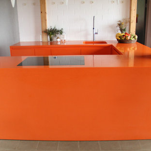 Inspiration for a mid-sized contemporary u-shaped open plan kitchen in Munich with an undermount sink, flat-panel cabinets, orange cabinets, solid surface benchtops, black appliances, grey floor and orange benchtop.