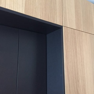 Inspiration for a mid-sized contemporary galley open plan kitchen in Munich with flat-panel cabinets, medium wood cabinets, granite benchtops, black splashback and with island.