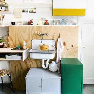 Kleine Eklektische Küche mit Landhausspüle, Rückwand aus Holz, gebeiztem Holzboden und grauem Boden in Berlin
