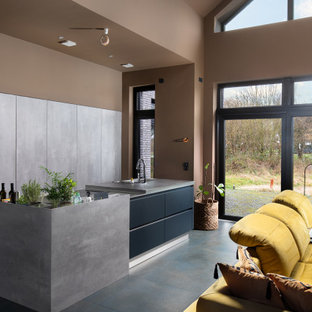 Offene, Zweizeilige, Große Moderne Küche mit integriertem Waschbecken, flächenbündigen Schrankfronten, hellbraunen Holzschränken, Elektrogeräten mit Frontblende, Kücheninsel, schwarzem Boden und grauer Arbeitsplatte in Bremen